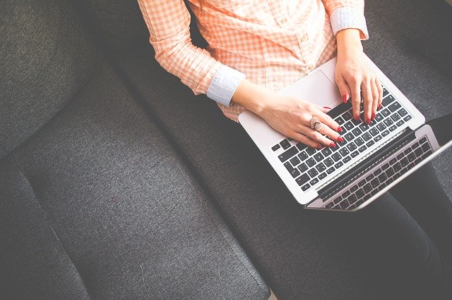 Woman blog writing on sofa